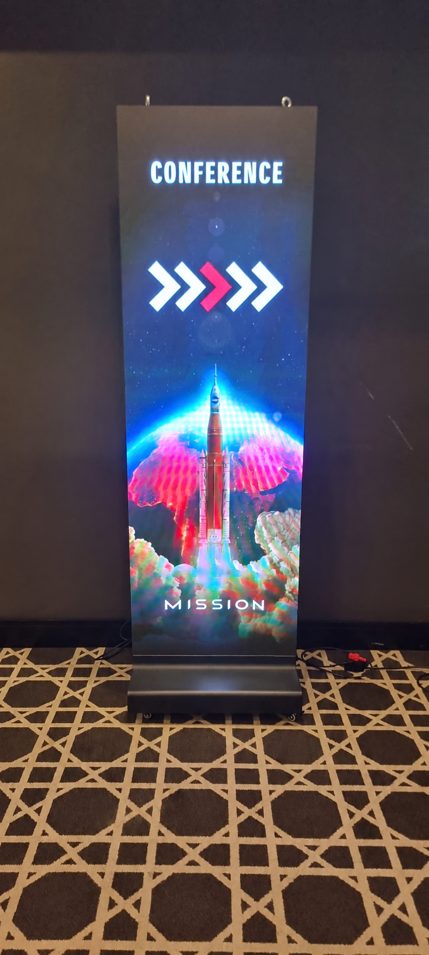 LED Poster displaying colourful rocket artwork at a conference